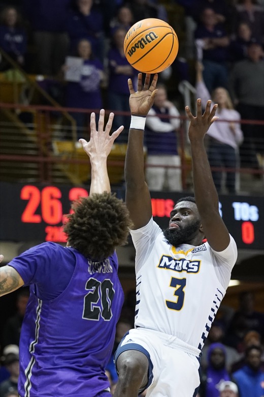 Chattanooga guard David Jean-Baptiste (3) shoots over Furman forward Jalen Slawson (20) in the second half of an NCAA college basketball championship game for the Southern Conference tournament, Monday, March 7, 2022, in Asheville, N.C. (AP Photo/Kathy Kmonicek)