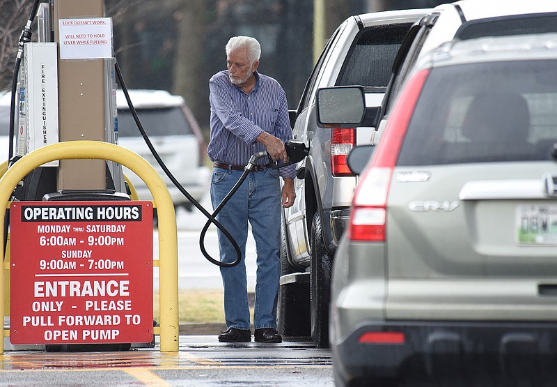 Staff file photo by Matt Hamilton / A motorist pumps gas at the Sam's Club Fuel Center on Lee Highway on Monday.