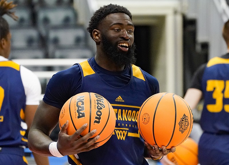 AP photo by Keith Srakocic / UTC's David Jean-Baptiste smiles as he tosses a ball to a teammate during the Mocs' NCAA tournament practice Thursday in Pittsburgh. UTC (27-7), the South Region's No. 14 seed, faces fourth-seeded Illinois (22-9) Friday night in the opening round.