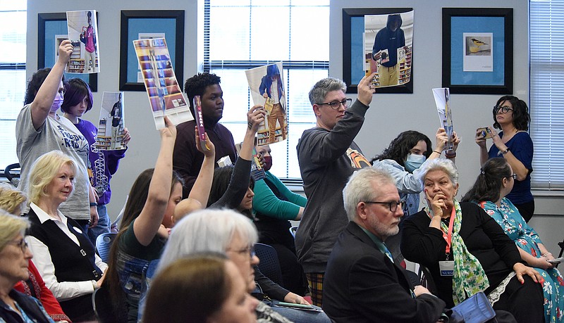 Staff Photo by Matt Hamilton / Supporters hold up photos as Taylor Lyons addresses the Hamilton County school board during a meeting Thursday, March 17, 2022.