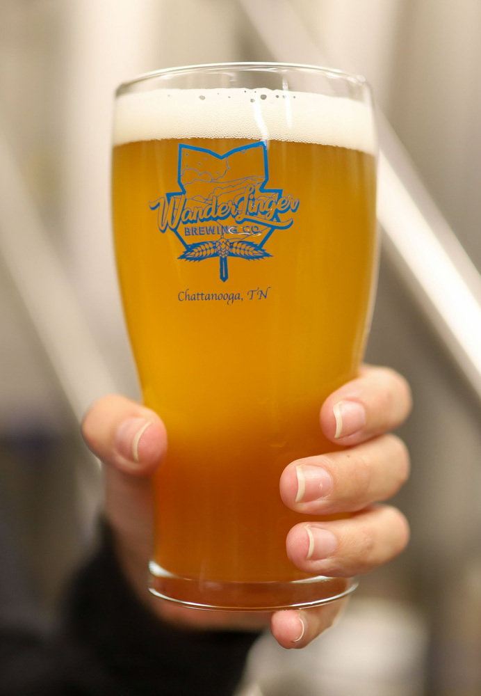 Staff photo by Olivia Ross / Molly Lamb shows off a beer at Wanderlinger Brewing Co. on Saturday, March 19, 2022.