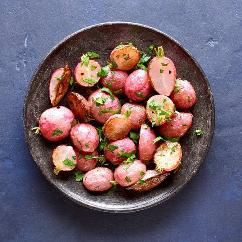 Roasted radishes on a plate. / Getty Images/iStock/Tatiana Volgutova