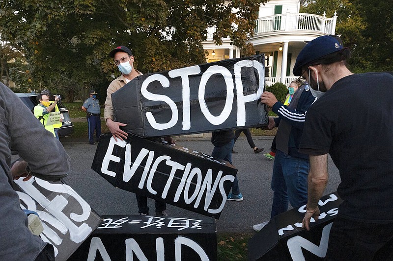 FILE - In this Oct. 14, 2020, file photo, housing activists erect a sign in front of Massachusetts Gov. Charlie Baker's house in Swampscott, Mass. The Justice Department said Saturday, Feb. 27, 2021 it will appeal a judge's ruling that found the federal government's eviction moratorium was unconstitutional. Prosecutors filed a notice in the case on Saturday evening, saying that it was appealing the matter the to the U.S. Court of Appeals for the Fifth Circuit. (AP Photo/Michael Dwyer, File)