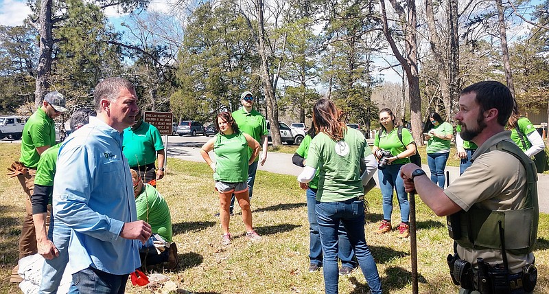 Staff photo by Mike Pare / Kevin Murphy, left, president of Publix Supermarkets, talks to an official at Harrison Bay State Park on Thursday, March 24, 2022. Murphy and Publix employees planted trees and took on other tasks at the park.