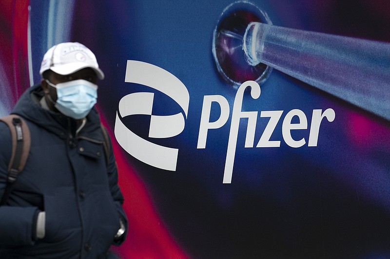 Photo by Mark Lennihan of The Associated Press / A man walks by Pfizer headquarters on Feb. 5, 2021, in New York.