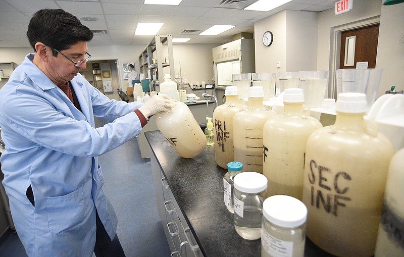 Staff Photo by Matt Hamilton / Dr. Gabriel Pérez takes a sample of wastewater to be tested for COVID-19 genetic material at the Moccasin Bend Wastewater Treatment Facility on Monday.
