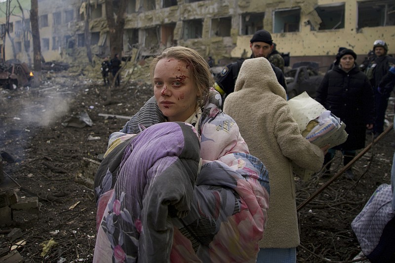 FILE - Mariana Vishegirskaya stands outside a maternity hospital that was damaged by shelling in Mariupol, Ukraine, Wednesday, March 9, 2022. Visheirskaya was taken to another nearby hospital where she gave birth the following day to a baby girl she named Veronika. “We were lying in wards when glass, frames, windows and walls flew apart,” she told AP, lying next to her newborn. "We don’t know how it happened. We were in our wards and some had time to cover themselves. Some didn’t.” (AP Photo/Mstyslav Chernov, File)