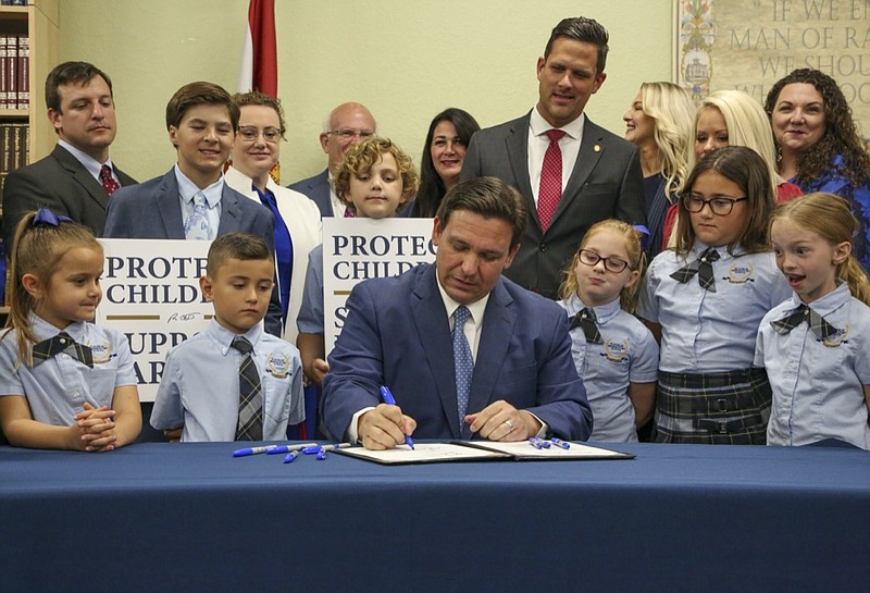 Florida Gov. Ron DeSantis signs the Parental Rights in Education bill at Classical Preparatory school Monday, March 28, 2022 in Shady Hills, Fla. (Douglas R. Clifford/Tampa Bay Times via AP)

