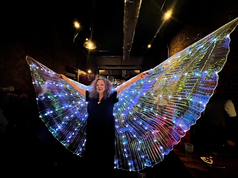 Contributed photo by Karen Diane Randall / Shannon Fuller holds a glittering pair of angel wings aloft at a birthday party and fundraiser held in her honor on Jan. 29. The photo will be made into a mural that will adorn the southern wall of Zarzour's Cafe.