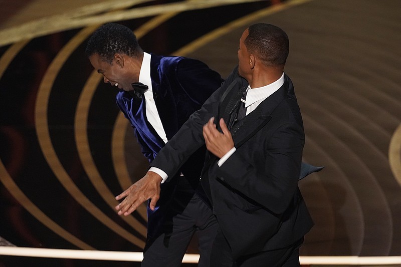 AP Photo/Chris Pizzello / Actor Will Smith, right, hits presenter Chris Rock while he was presenting the award for best documentary feature at the Oscars last Sunday.