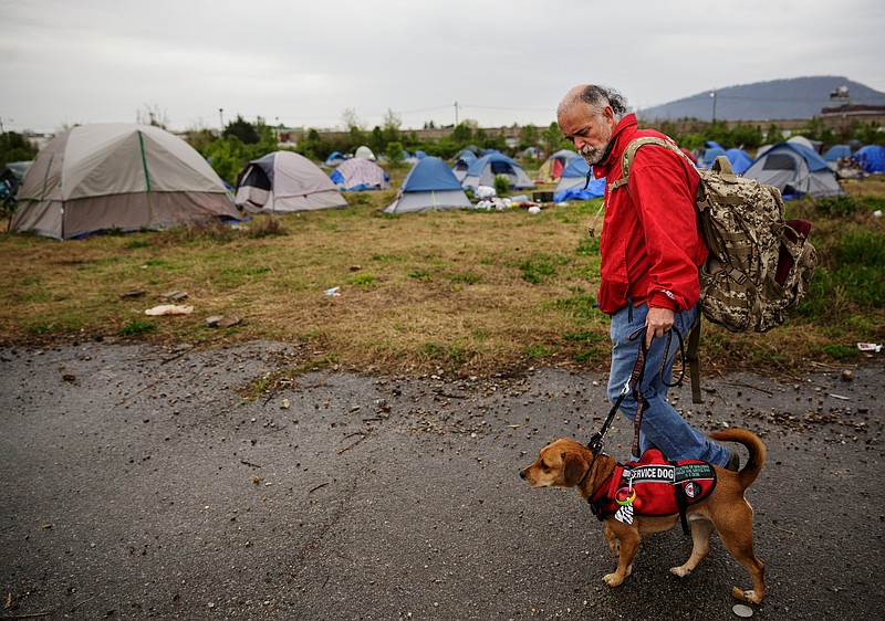 taff file photo / A homeless man walks to the tent that he shares with a friend in a homeless encampment behind the Chattanooga’s wellness center on East 11th Street in 2018. City service coordinators were there trying to help residents find temporary housing, because the camp was located on a toxic brownfield.