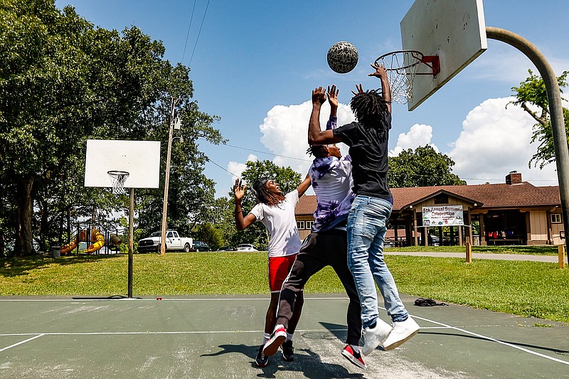 Staff photo by Troy Stolt / Traevius Evans, 15, Justin Lewis, 16, and Deandre Jackson, 15, play basketball during the annual End of the Summer Outdoor Celebration at Booker T. Washington State Park on Friday, July 16, 2021, in Chattanooga, Tenn. At the urging of local lawmakers, Gov. Bill Lee is now recommending $3.9 million in state budget funding to renovate or replace the park's old bath house to create an event center.