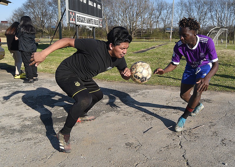 Staff Photo by Matt Hamilton / Christian Ramos, left, tries to dribble a soccer ball past teammate Amos Vyizigiro before soccer practice at Howard School on Thursday, March 3, 2022. 