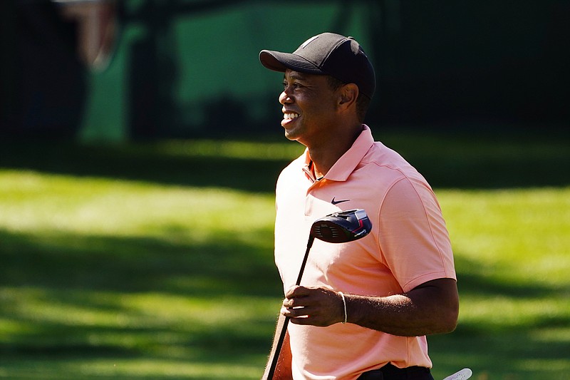AP photo by Matt Slocum / Tiger Woods smiles as he leaves the driving range Sunday at Augusta National Golf Club. Woods was in Georgia four days before the Masters tees off, but he wrote Sunday morning on Twitter that he was still trying to determine whether he will play the year's first major, where he is a five-time winner.