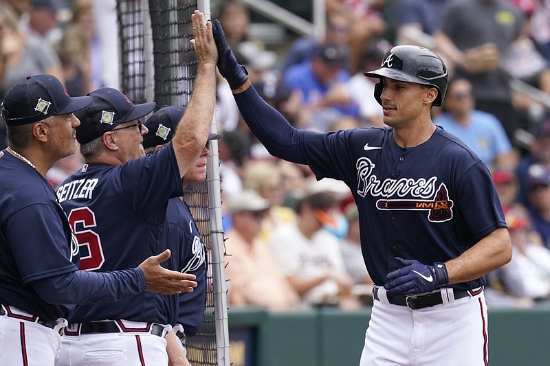 Atlanta Braves hitting coach Kevin Seitzer, left, gets a high five from Atlanta Braves first baseman Matt Olson, right, after Olson's solo home run in the first inning during spring training baseball game against the Boston Red Sox at CoolToday Park, Sunday, April 3, 2022, in North Port, Fla. (AP Photo/Steve Helber)