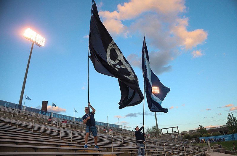 Staff photo by Olivia Ross  / Topher Kersting and David Adams wave Chattanooga FC flags weighing, with the wind, nearly 70 pounds during the team's U.S. Open Cup second-round match against Memphis 905 FC on Thursday night at Finley Stadium.