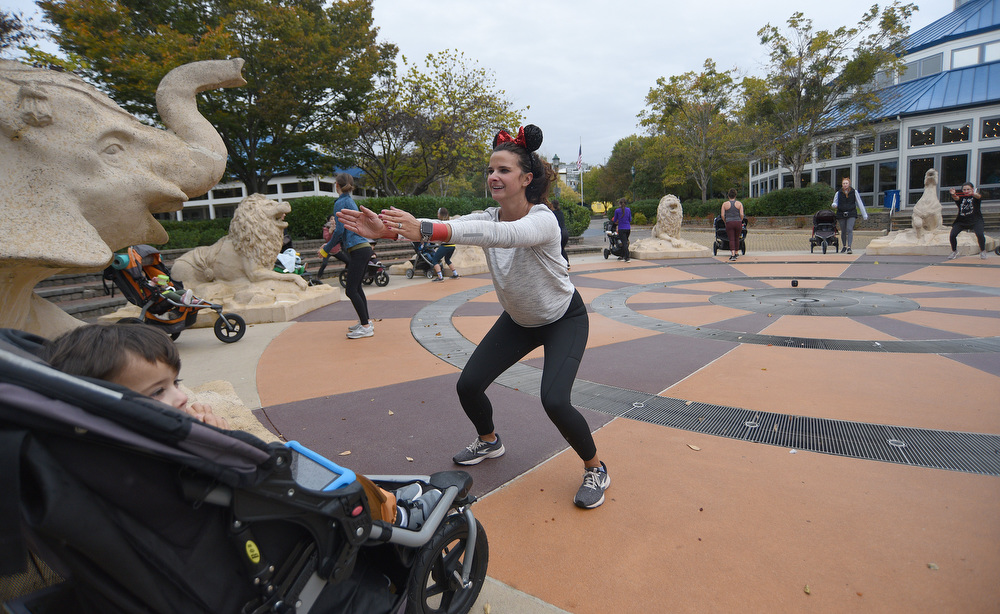 Staff Photo by Matt Hamilton / Chattanooga resident Marissa Shrum works out as her son Brady, 3, watches on Thursday in Coolidge Park. Fit4Mom Chattanooga teamed up with Bella Ballerina ballet studio to have a Halloween costume dance party in Coolidge Park on Thursday, October 28, 2021.