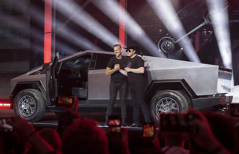 Tesla CEO Elon Musk, right, and vehicle designer Franz von Holzhausen speak at the "Cyber Rodeo" grand opening celebration for the new $1.1 billion Tesla Giga Texas manufacturing facility in Austin, Texas, on Thursday April 7, 2022. The event marks the opening of the new factory in Travis County, which is Tesla's new home after a move from California. (Jay Janner /Austin American-Statesman via AP)