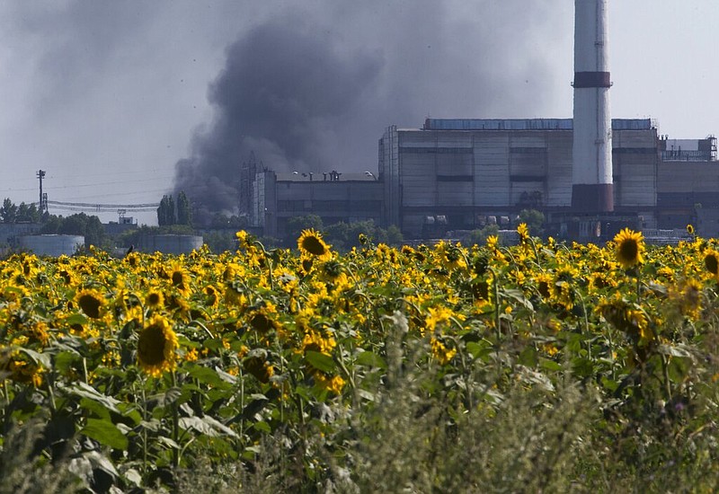Smoke from an oil refinery rises over a field of sunflowers near the city of Lisichansk, Luhansk region, eastern Ukraine on July 26, 2014. Prices for food commodities like grains and vegetable oils reached their highest levels ever last month because of Russia's war in Ukraine and the "massive supply disruptions" it is causing, the United Nations said Friday, April 8, 2022. (AP Photo/Dmitry Lovetsky)