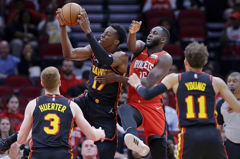 AP phot by Michael Wyke / The Atlanta Hawks' Onyeka Okongwu pulls in a rebound in front of Houston Rockets forward Usman Garuba, center right, as Atlanta guards Kevin Huerter and Trae Young look on during Sunday's game in Houston.