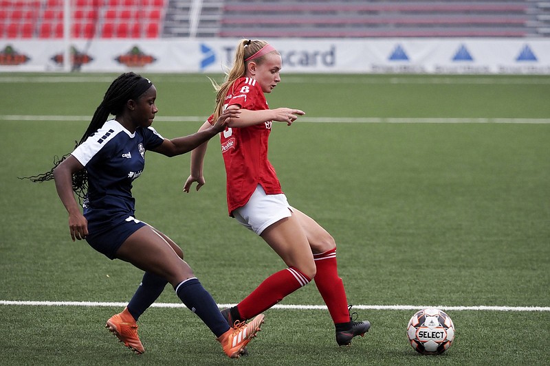 Staff photo by C.B. Schmelter / Chattanooga Lady Red Wolves Soccer Club's Zoey Mize (25) works against North Alabama Soccer Coalition's Gabriel Clarke (4) during a Women's Premier Soccer League match at CHI Memorial Stadium on Sunday, June 6, 2021 in East Ridge, Tenn.