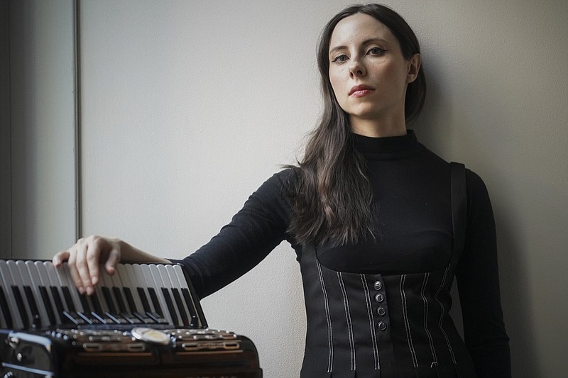 Erica Mancini, an accordionist, poses before taking the stage to perform in a Ukrainian avant garde jazz opera, Friday June 17, 2022, at Bohemian National Hall in New York. Mancini has suffered three COVID-19 infections: one at the beginning of the pandemic, one last year and one in May of this year. Medical experts warn that we'll be seeing more multiple reinfections given how long the pandemic is stretching on. (AP Photo/Bebeto Matthews)


