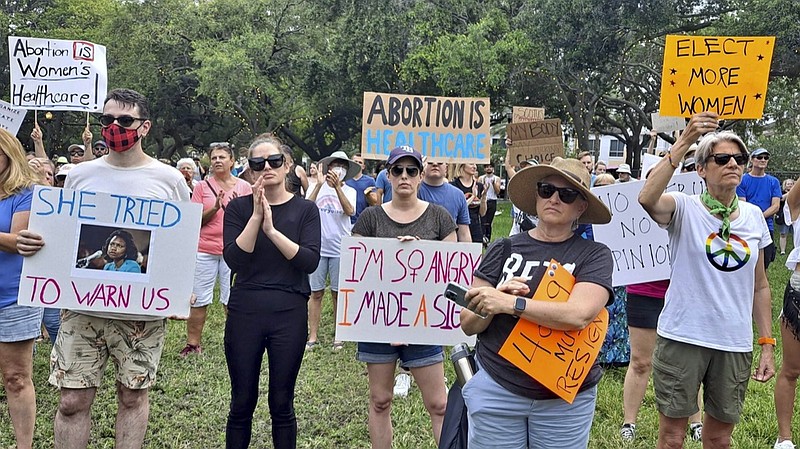 Abortion-rights marchers hold signs during a rally Friday, June 24, 2022 in St. Petersburg, Fla. The Supreme Court on Friday stripped away women's constitutional protections for abortion, a fundamental and deeply personal change for Americans' lives after nearly a half-century under Roe v. Wade. The court's overturning of the landmark court ruling is likely to lead to abortion bans in roughly half the states. (Jefferee Woo/Tampa Bay Times via AP)