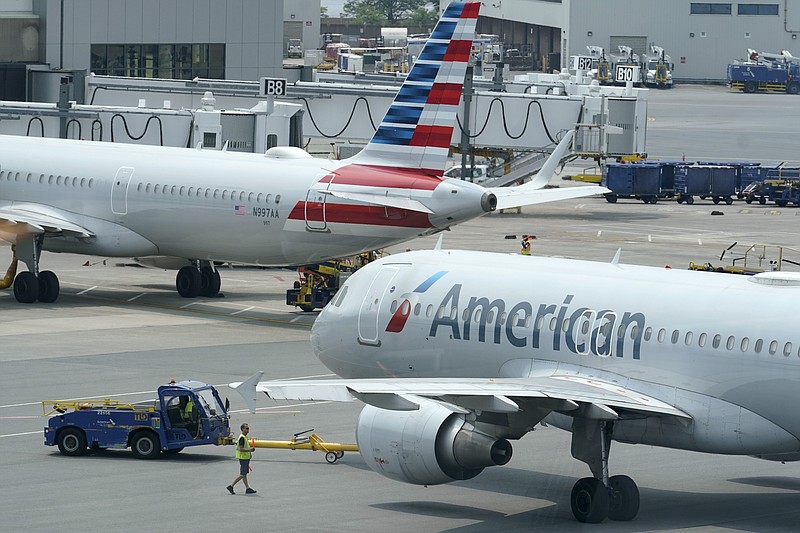 FILE -American Airlines passenger jets prepare for departure, Wednesday, July 21, 2021, near a terminal at Boston Logan International Airport, in Boston. Airlines facing a pilot shortage are boosting pay. The CEO of American Airlines said Thursday, June 30, 2022 that his airline has offered to raise pilot wages by nearly 17% through the end of 2024.(AP Photo/Steven Senne, File)