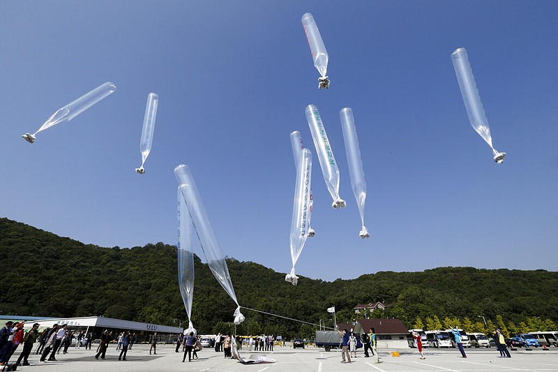 North Koran defectors release balloons carrying leaflets condemning North Korean leader Kim Jong Un and his government's policies, in Paju, near the border with North Korea, South Korea on Oct. 10, 2014. North Korea suggested Friday, July 1, 2022 its COVID-19 outbreak began in people who had contact with balloons flown from South Korea, a highly questionable claim that appeared to be an attempt to hold its rival responsible amid increasing tensions. (AP Photo/Ahn Young-joon, File)