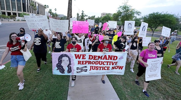 Thousands of protesters march around the Arizona Capitol in protest after the Supreme Court decision to overturn the landmark Roe v. Wade abortion decision Friday, June 24, 2022, in Phoenix. The U.S. Supreme Court ruling overturning Roe v. Wade has legal advocates, prosecutors and residents of red states facing a legal morass created by decades of often conflicting anti-abortion legislation. In Arizona, Republicans are fighting among themselves over whether a 121-year-old anti-abortion law that precedes statehood should be enforced over a 2022 version. (AP Photo/Ross D. Franklin, File)