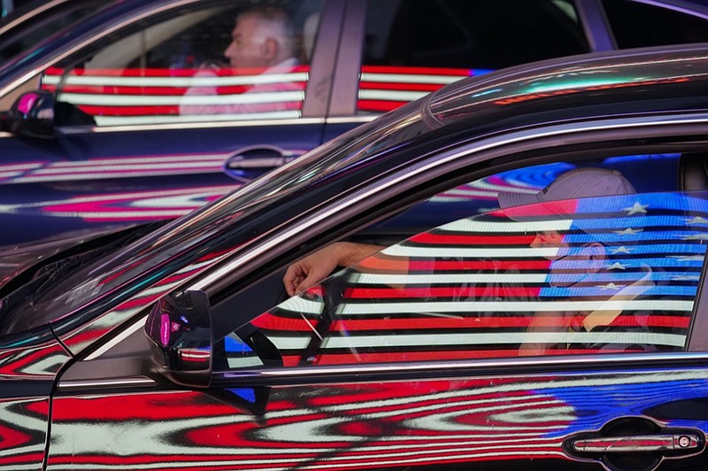 The neon flag on an Army recruiting station is reflected on cars at a red light in New York's Times Square, Oct. 14, 2021. (AP Photo/Mary Altaffer, File)