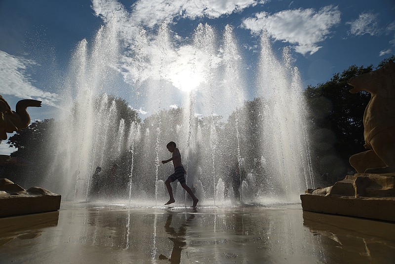 Children cool off in the fountain at Coolidge Park on Saturday, July 2, 2022. / Staff photo by Matt Hamilton
