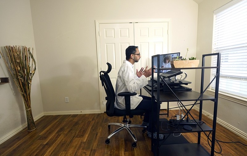 FILE - Medical director of Doctor on Demand Dr. Vibin Roy speaks to a patient during an online primary care visit conducted from his home, April 23, 2021, in Keller, Texas. A new poll shows that many Americans don't expect to rely on the digital services that became commonplace during the pandemic after COVID-19 subsides. (AP Photo/LM Otero, File)