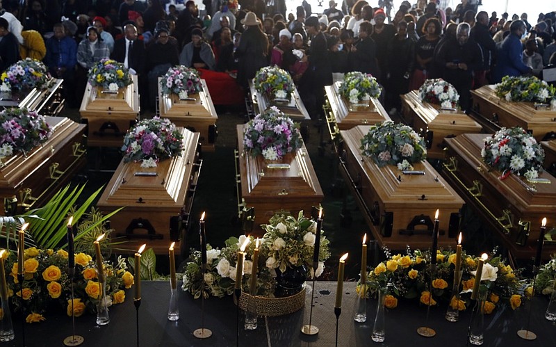 A view of the coffins during a funeral service held in Scenery Park, East London, South Africa, Wednesday, July 6, 2022. More than a thousand grieving family and community members are attending the funeral in South Africa's East London for 21 teenagers who died in a mysterious tragedy at a nightclub nearly two weeks ago. South African President Cyril Ramaphosa is due to give the eulogy for the young who died. (AP Photo)