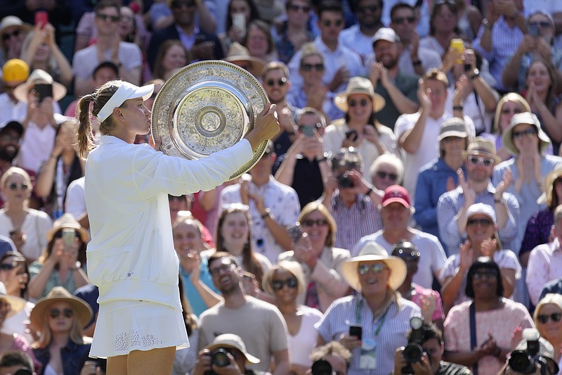 AP photo by Kirsty Wigglesworth / Elena Rybakina kisses her trophy as she celebrates after beating Ons Jabeur 3-6, 6-2, 6-2 on Saturday at Wimbledon for her first Grand Slam championship.