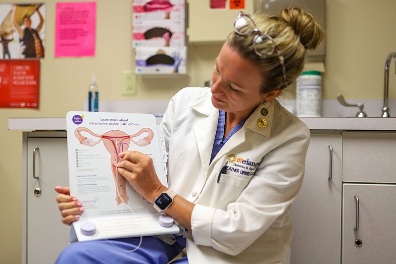 Staff Photo by Olivia Ross / Obstetrician and gynecologist Dr. Heather Urrego at Erlanger holds up a diagram about IUDs on Thursday. Since the overturning of Roe v. Wade, Chattanooga providers have seen an increase in contraception demand.
