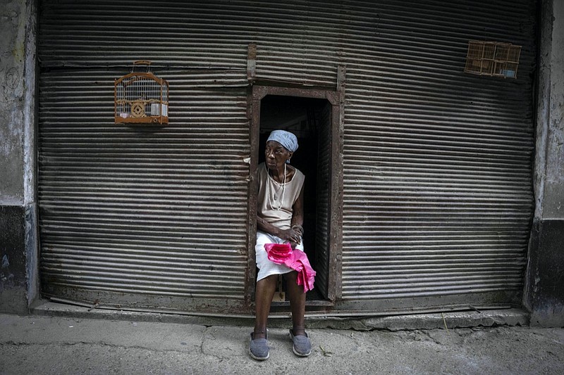 A woman who sells plastic shopping bags, waits for customers in Havana, Cuba, Saturday, July 9, 2022. A year after the largest protests in decades shook Cuba's single-party government, the economic and political factors that caused them largely remain. (AP Photo/Ramon Espinosa)