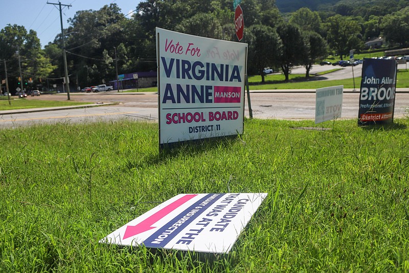 Staff photo by Olivia Ross / A knocked-over sign reads "Candidate that was at the January 6 Insurrection" in a similar font and color scheme as Virginia Anne Manson's campaign signs. Manson is running for school board.