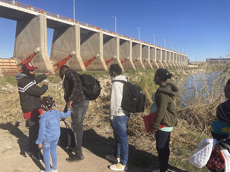 AP File Photo/Elliot Spagat / A Mexican smuggler guides a Haitian family across the Morelos Dam over the Colorado River from Los Algodones, Mexico, earlier this year to Yuma, Ariz., on the other side.