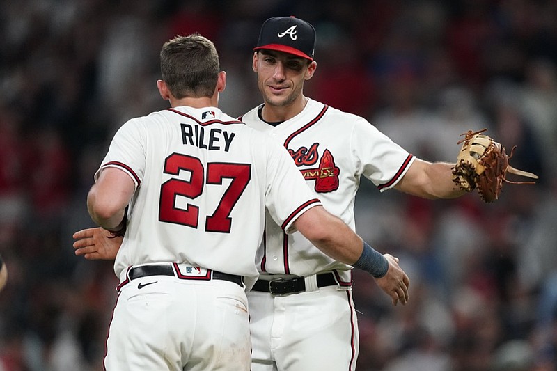 Atlanta Braves first baseman Matt Olson (28) and third baseman Austin Riley (27) embrace after defeating the New York Mets in a baseball game Tuesday, July 12, 2022, in Atlanta. (AP Photo/John Bazemore)