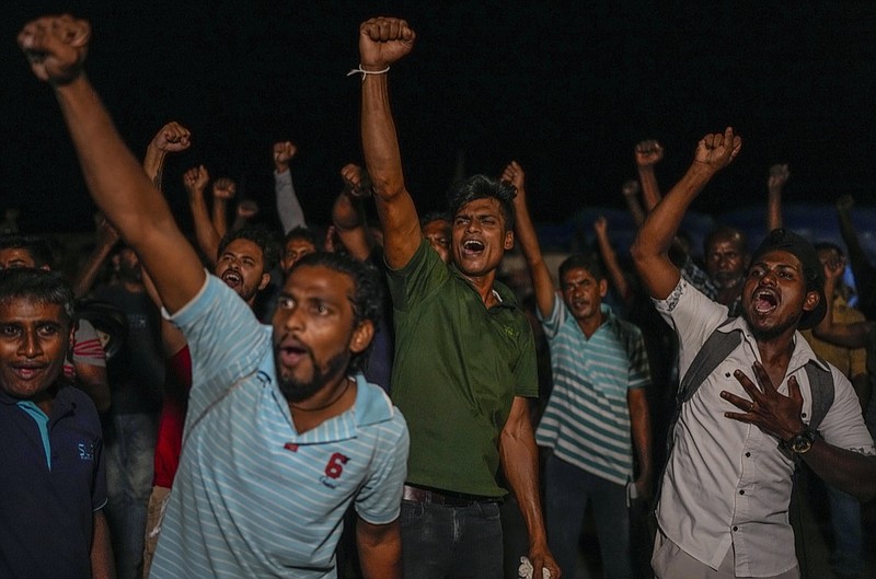 Sri Lankans celebrate as they react to early reports of President Gotabaya Rajapaksa's resignation in Colombo, Sri Lanka, Thursday, July 14, 2022. Embattled Rajapaksa fled a day earlier under pressure from demonstrators furious over the island nation's economic collapse. He finally emailed his resignation Thursday, a day later than promised, according to an official. (AP Photo/Rafiq Maqbool)