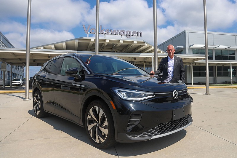 Staff photo by Olivia Ross / Volkswagen Chattanooga CEO Chris Glover stands with a electric ID.4 SUV at the entrance to the plant on July 12, 2022.
