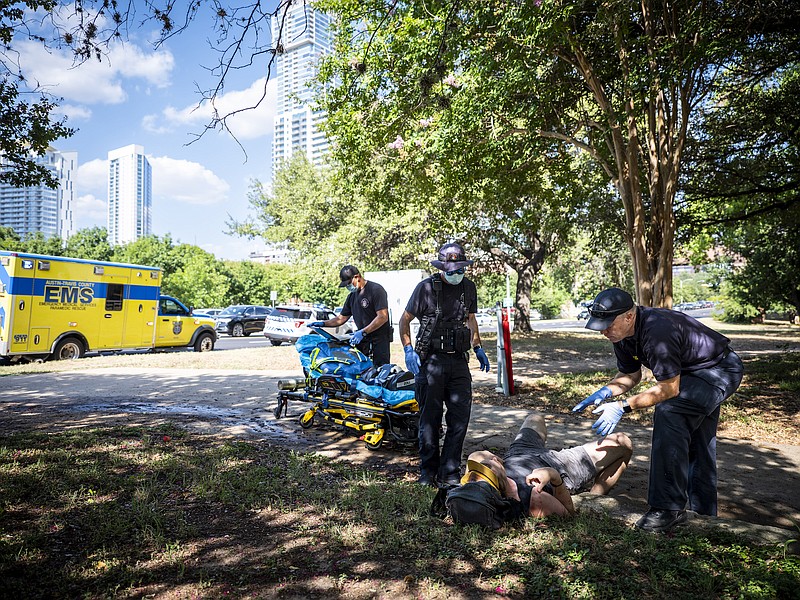 Photo by Matthew Busch of The New York Times / First responders tend to a man in distress and showing signs of heat exhaustion near Town Lake Trail in Austin, Texas, on Wednesday July 20, 2022.