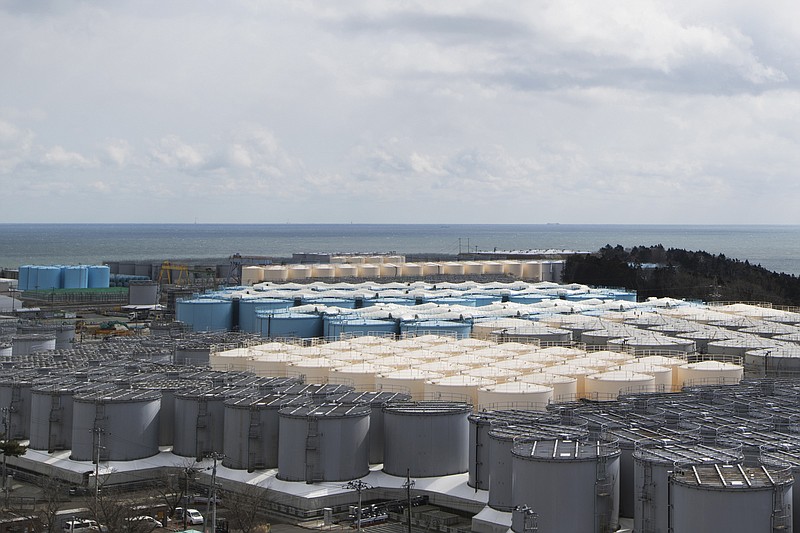FILE - This photo shows tanks (in gray, beige and blue) storeing water that was treated but is still radioactive after it was used to cool down spent fuel at the Fukushima Daiichi nuclear power plant in Okuma town, Fukushima prefecture, northeastern Japan, on Feb. 27, 2021. Japan's nuclear regulator on Friday, July 22, 2022, approved the release of treated radioactive wastewater from the wrecked Fukushima nuclear power plant into the sea next year. (AP Photo/Hiro Komae, File)