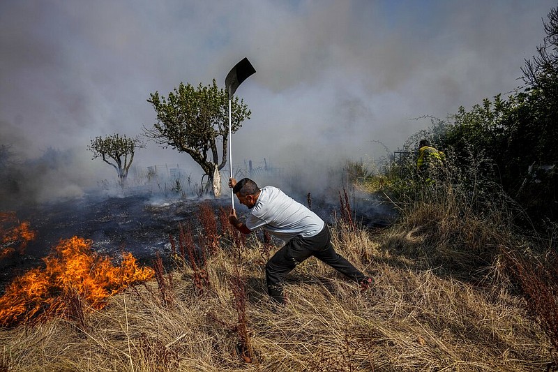 A local resident fights a forest fire with a shovel during a wildfire in Tabara, north-west Spain, July 19, 2022. Major wildfires in Europe are starting earlier in the year, becoming more frequent, doing more damage and getting harder to stop. And, scientists say, they're probably going to get worse as climate change intensifies unless countermeasures are taken. (AP Photo/Bernat Armangue, File)