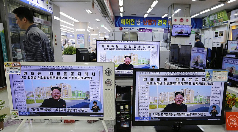 A man walks past TV monitors displaying a news program at an electronic shop in Seoul, South Korea, on Oct. 14, 2014, showing a North Korean newspaper with a photo of North Korean leader Kim Jong Un smiling, reportedly during his first public appearance in five weeks in Pyongyang, North Korea. The writing reads, "Honorable Kim Jong Un." South Korea plans to lift its decades-long ban on public access to North Korean television, newspapers and other media as part of its efforts to promote mutual understanding between the rivals, officials said Friday, July 22, 2022, despite animosities over the North's recent missile tests. (AP Photo/Ahn Young-joon, File)