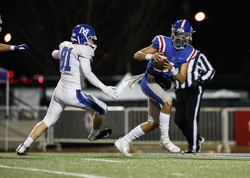 Staff photo by Troy Stolt / / MUS quarterback George Hamsley (5) is chased into the end zone by McCallie defensive lineman Carson Gentle (81) before being sacked resulting in a safety during the Division II Class AAA State Football Playoffs between McCallie and MUS at Tucker stadium on Thursday, Dec. 3, 2020 in Cookeville, Tenn.