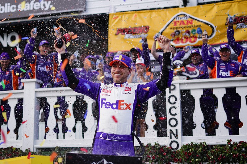 ADDS THAT HAMLIN WAS LATER DISQUALIFIED - Denny Hamlin (11) celebrates after winning a NASCAR Cup Series auto race at Pocono Raceway, Sunday, July 24, 2022, in Long Pond, Pa. NASCAR stripped Hamlin of his win when his No. 11 Toyota failed inspection and was disqualified, awarding Chase Elliott the Cup Series victory. (AP Photo/Matt Slocum)