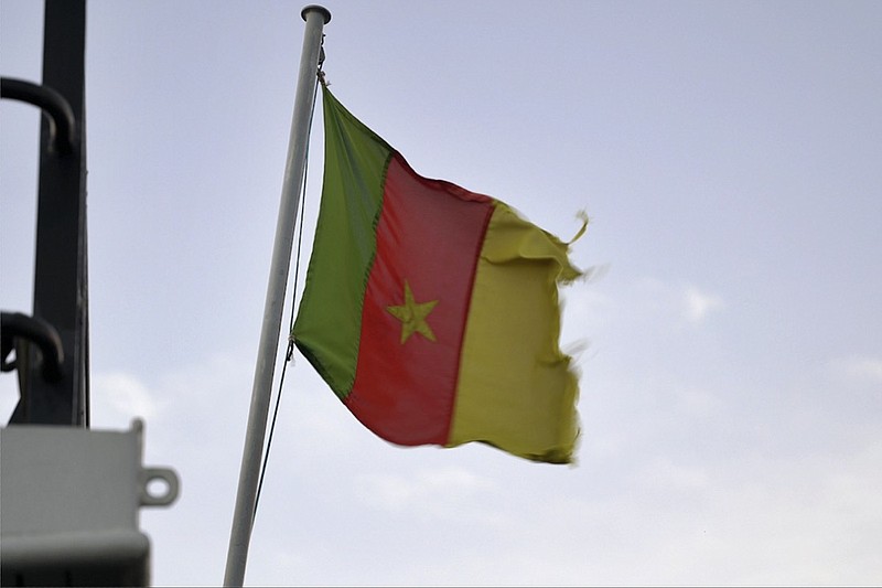 A Cameroonian flag flies on a ship at the port in Douala, Cameroon, on April 10, 2022. In recent years, the country has emerged as one of several go-to countries for the widely criticized "flags of convenience" system, under which companies can - for a fee - register their ships in a foreign country even though there is no link between the vessel and the nation whose flag it flies. (AP Photo/Grace Ekpu)