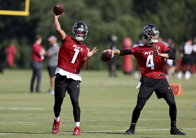 Atlanta Journal-Constitution photo by Jason Getz via AP / Marcus Mariota, left, and Desmond Ridder throw during the Atlanta Falcons' training camp Wednesday in Flowery Branch, Ga. The Falcons have only three quarterbacks in camp, and Feleipe Franks is spending most of his time at tight end right now.